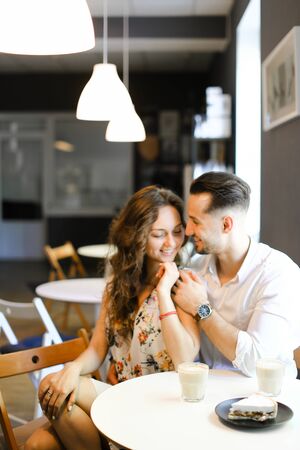 Young caucasian husband hugging lovely wife at cafe and resting. Concept of positive feelings, friendship and love.の写真素材