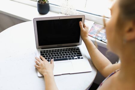 Blurry caucsian woman working with laptop, focus on computer. Concept of modern technology.