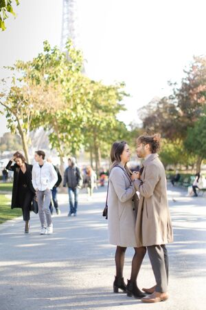 Afro american young man hugging caucasian girlfriend and walking in park.の写真素材