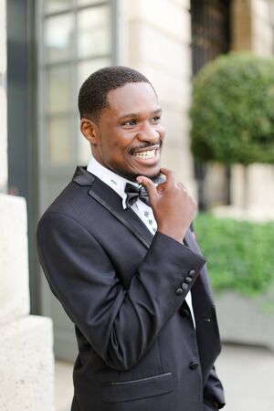 Afro american happy good looking male person wearing suit and smiling outside. Concept of black businessman.の写真素材