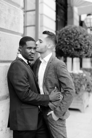 Black and white photo afro american gay hugging european man outdoors. Concept of lgbt and same sex couple.の写真素材