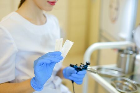 Female cosmetologist inserting needle into microblading device at beauty salon. Concept of cosmetology equipment for permanent makeup.の写真素材