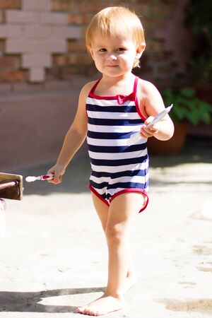 Blonde little female child standing outside. Concept of childhood and summer season.の写真素材