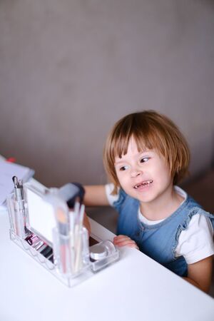 Little female baby playing inside and wearing blue clothes. Concept of childhood and carefree.の写真素材
