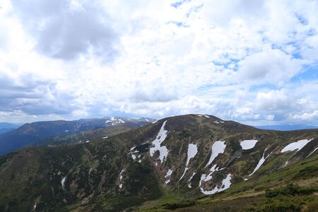 Green Alps mountains in summer season with clouds in background. Concept of nature landscapes.の写真素材