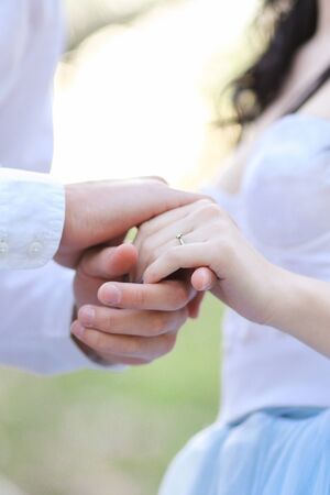 Closeup young male and female hands holding each other. Concept of relationhip and feelings.の写真素材