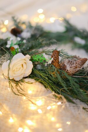 Green wreath and shimmering yellow garlands. Concept of handmade decorations for Christmas and winter holidays.の写真素材