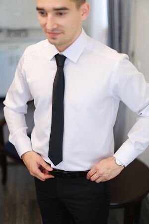 Young caucasian businessman wearing white shirt and black tie, standing and smiling. Concept of business wear style and successful people.の写真素材