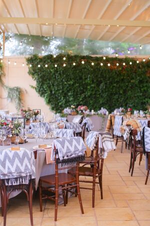 Wineglasses on tables at restaurant outside. Concept of summer cafe and catering establishment.の写真素材