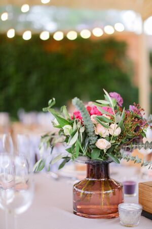 Vase with flowers on table at restaurant, soft focus background. Concept of floristic decorations for catering establishments.の写真素材