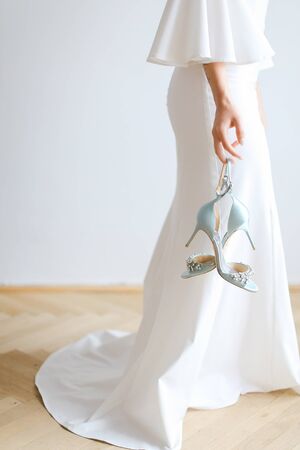 Closeup bride keeping dress and shoes. oncept of wedding day.の写真素材