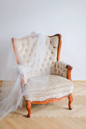 Arm chair and white bridal veil indoors. Concept of wedding day and decorations.の写真素材