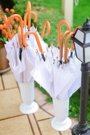 White umbrellas hanging outside near lantern. Concept of gardening and rain.の写真素材