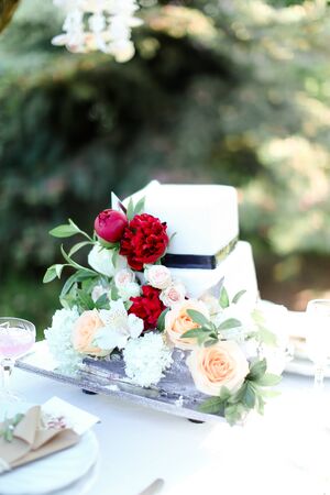 White wedding cake with red peony. Concept of bridal sweets.の写真素材