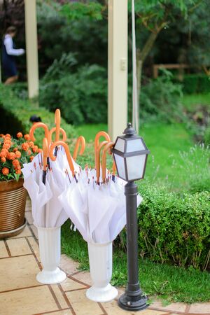 Umbrellas hanging outside near lantern. Concept of gardening and rain.の写真素材