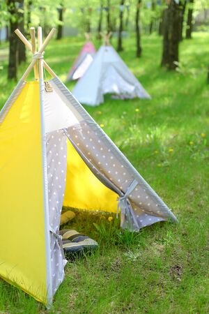 Yellow and blue tents in park. Concept of summer vacations.の写真素材