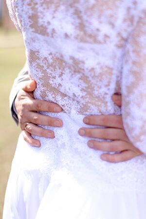 Male hands on bride back. Concept of wedding and happy couple.の写真素材