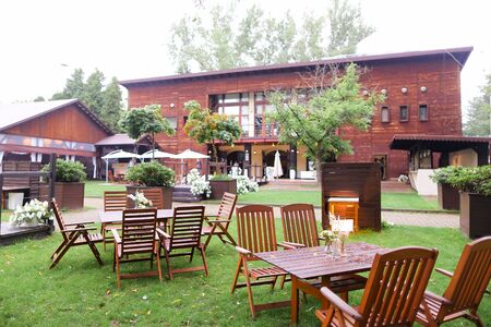 Wooden tables and chairs outside near restaurant. Concept of resort and catering establishment.の写真素材