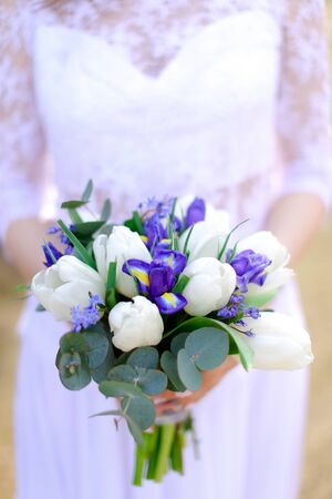 Closeup bride keeping bouquet of flowers. Concept of floristic art and wedding.の写真素材