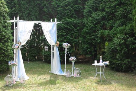 White wedding arch in park. Concept of bridal decorations and elements.の写真素材