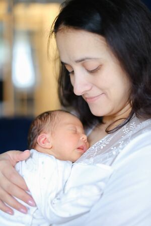 Young mother holding newborn baby. Concept of motherhood and babies.の写真素材