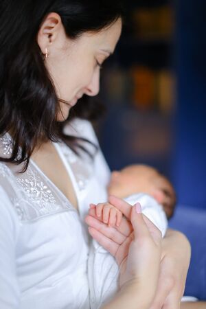 Young happy mother holding newborn baby. Concept of motherhood and babies.の写真素材