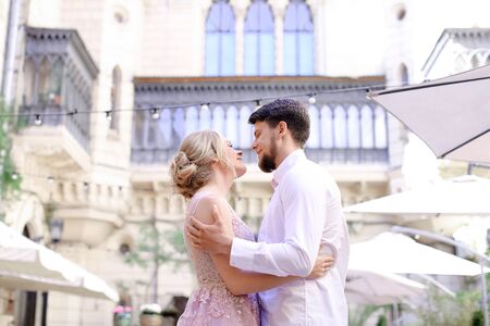 Happy young married couple hugging with building background. Concept of wedding and architecture.の写真素材