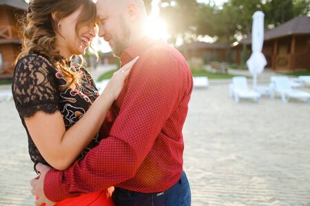 Bald european man wearing red shirt and hugging woman. Concept of relationships and romantic love.の写真素材
