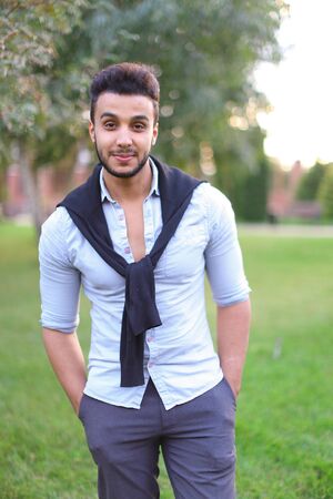 Young beautiful hispanic man walking in park. Concept of stylish youth and foreign students.の写真素材
