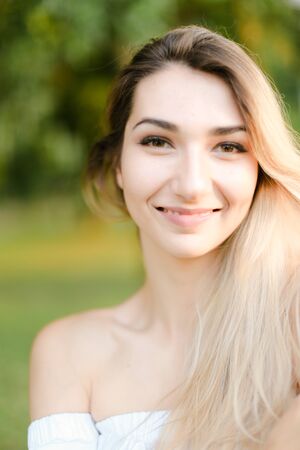 Portrait of young nice smiling girl, green background. Concept of beauty and everyday makeup.の写真素材
