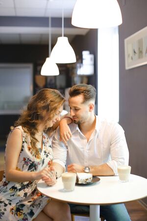 Young caucasian woman and man having lunch at cafe, resting and drinking coffee. Concept of of love, catering establishment and happy couple.の写真素材