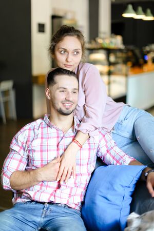 Young happy wife sitting with man and hugging. oncept of spending time together and love.の写真素材