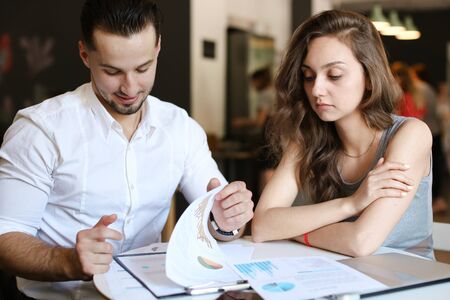 Young businessman and woman working with documents and diagrams. Concept of business and occupation.の写真素材