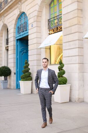 Young caucasian man walking in city and wearing grey suit. Concept of fashion and businessman.の写真素材