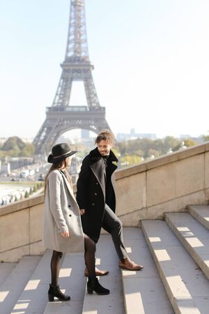 Afro american boy and caucasian girl walking on stairs, Eiffel Tower in background, Paris.Concept of love and international couple, vacations in France.の写真素材