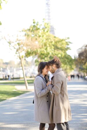 Afro american man hugging caucasian girlfriend and walking in park.の写真素材
