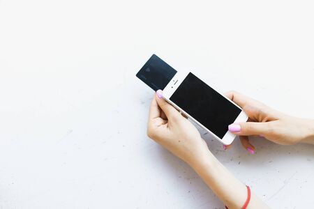 Female hands keeping credit card and smartphone in white background with copyspace. Concept of buying medicines online.の写真素材