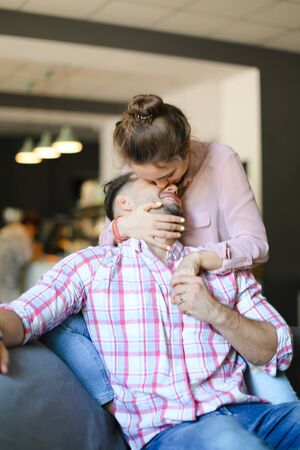 Young caucasian wife kissing and hugging husband at home. Concept of spending time together, relationship and love.の写真素材
