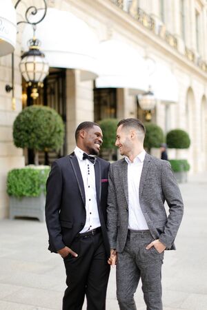 Afro american and caucasian happy gays walking outside in city. Concept of same sex male couple.の写真素材