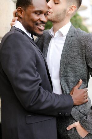 Afro american happy gay hugging european man outdoors. Concept of lgbt and same sex couple.の写真素材
