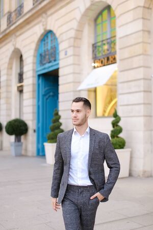 Young caucasian handsome man walking in city and wearing grey suit. Concept of fashion and businessman.の写真素材