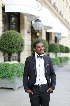 Afro american happy man wearing suit and standing outside. Concept of black businessman.の写真素材
