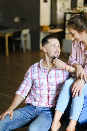 Young girl sitting with boyfriend at home and talking. Concept of happy couple, spending time together and relationship.の写真素材