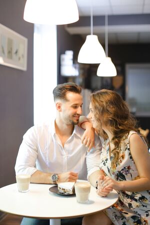 Young happy woman and man having lunch at cafe, resting and drinking coffee. Concept of of love, catering establishment and happy couple.の写真素材