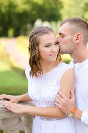 Happy groom kissing bride outside. Concept of bridal photo session adn wedding, relationship and feelings.の写真素材