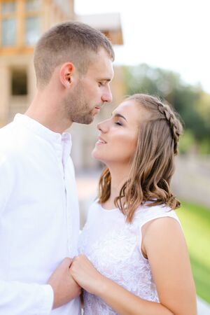 Groom kissing bride and holding hands outdoors. Concept of wedding and bridal photo session, relationship.の写真素材