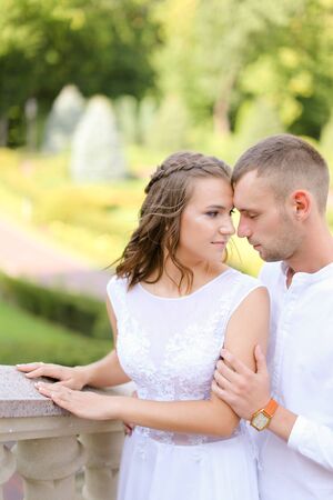 Happy pretty bride and groom holding hands and standing outdoors. Concept of relationship, wedding and bridal photo session.の写真素材