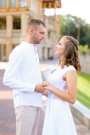 Happy bride and groom holding hands and standing outdoors. Concept of relationship, wedding and bridal photo session.の写真素材