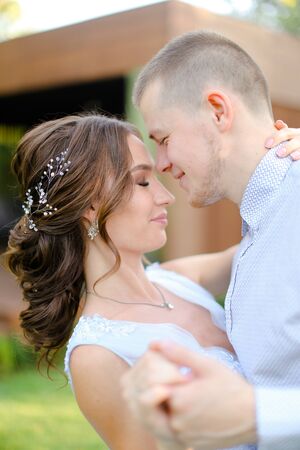 Close up pretty fiancee dancing with groom outside. Concept of wedding and bridal photo session.の写真素材