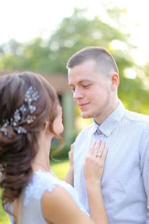 Close up caucasian fiancee hugging groom in park. Concept of wedding and love.の写真素材